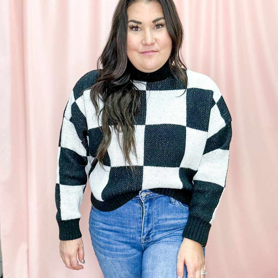 Checkered Sweater, large black and white squares with a high mock neck that is ribbed sweater