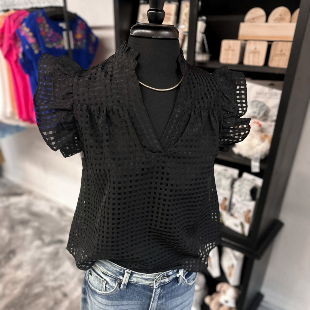 Black checkered short sleeve top with ruffle sleeves and a v-neckline.