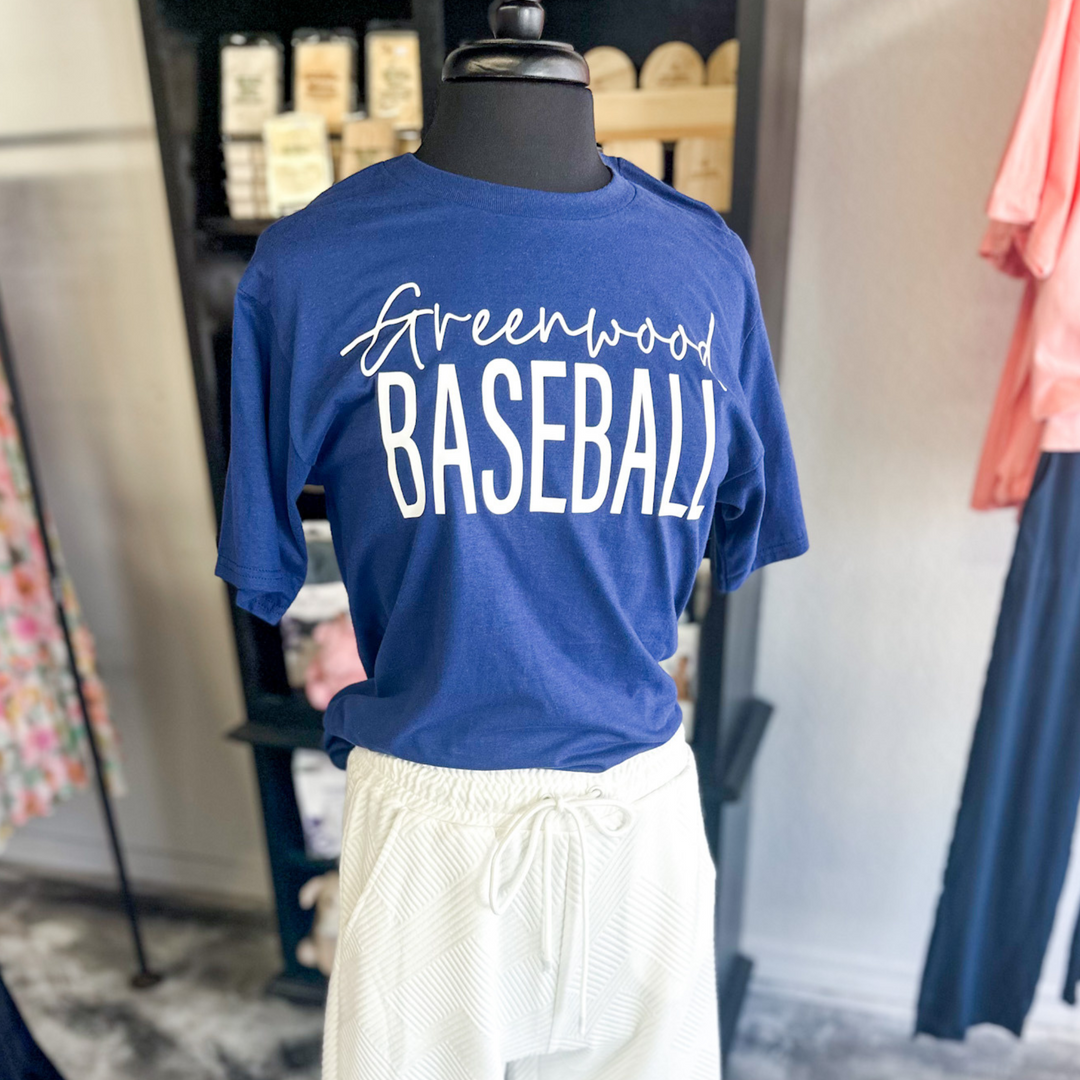 Navy blue short sleeve with white writing, says greenwood baseball