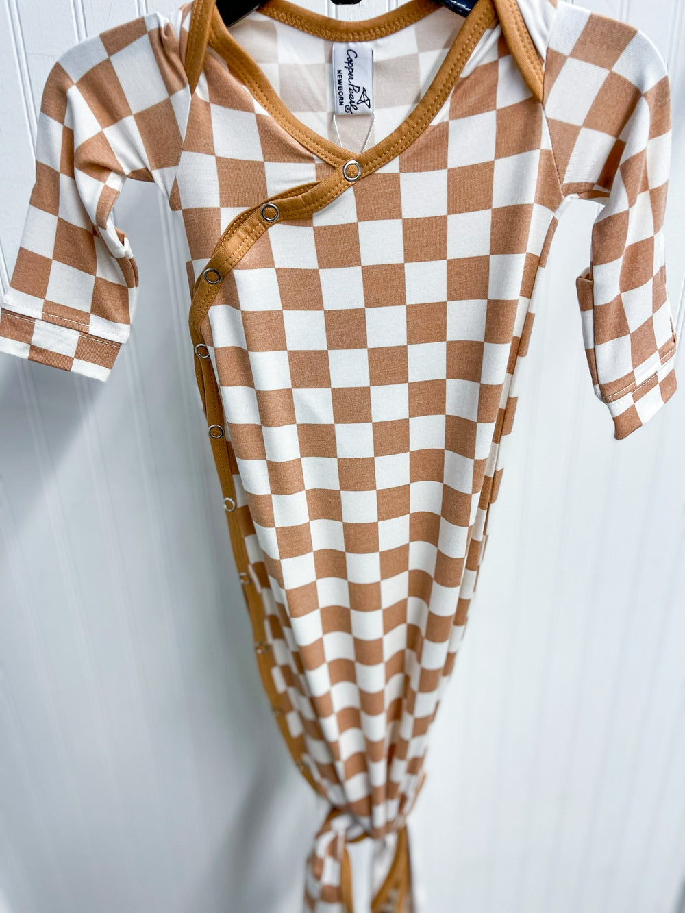 copper pearl knotted baby gown, rad print, brown and white checkered print, brown trim, snap button, knotted at the bottom so it can grow with baby. 
