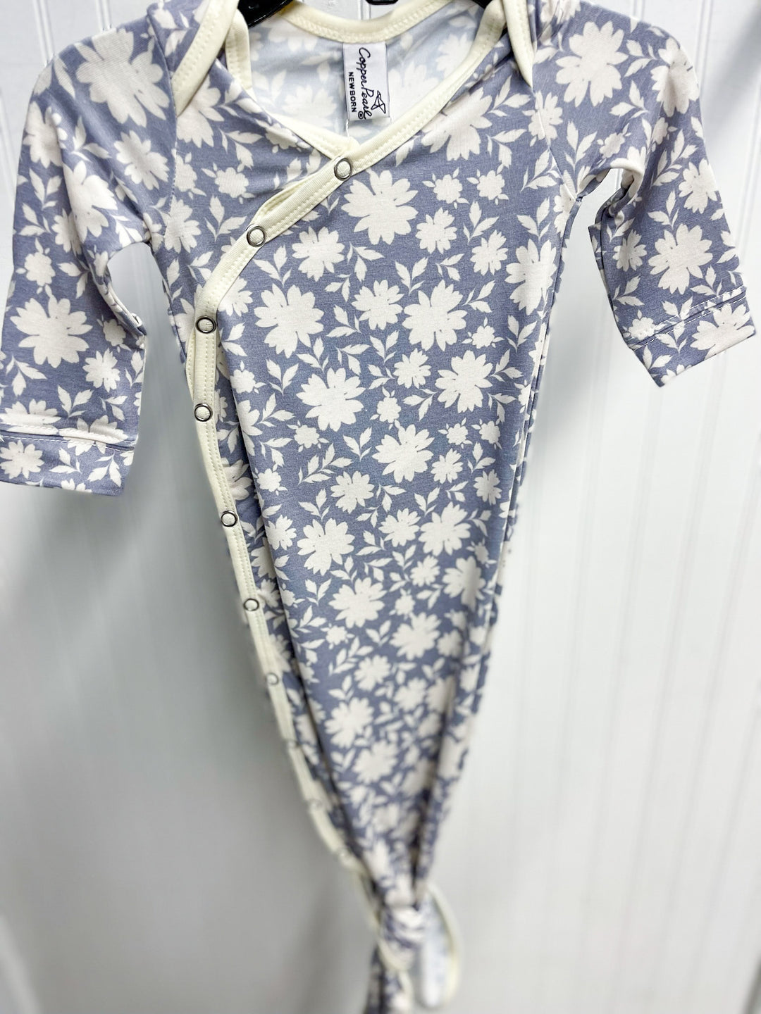copper pearl knotted baby gown, Lacie print, lilac background with cream flowers, cream trim, snap button, knotted at the bottom so it can grow with baby.