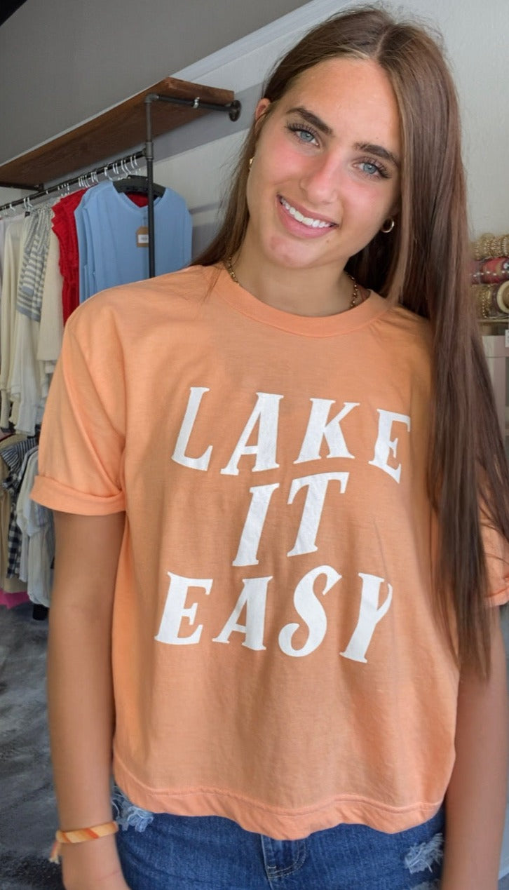 short sleeve orange shirt, says lake it easy in white
