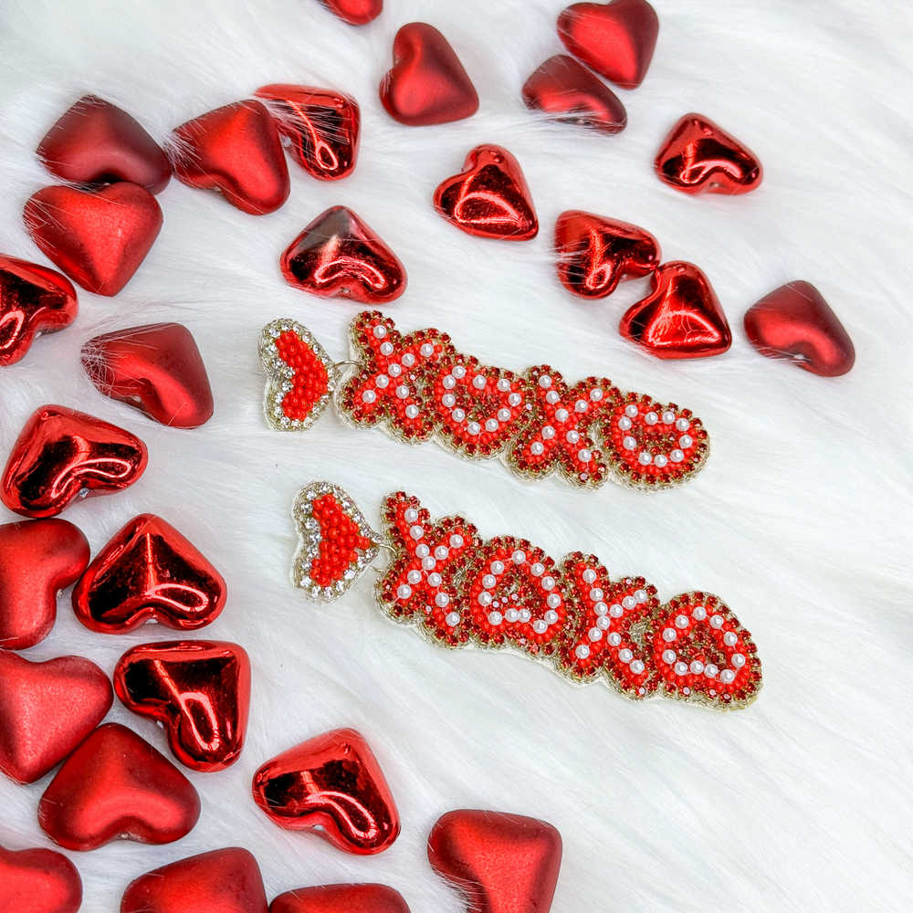 valentine's day beaded earrings. small red heart with red xo xo following in a downward direction, red letters have a small white beaded detail and outlined in gold