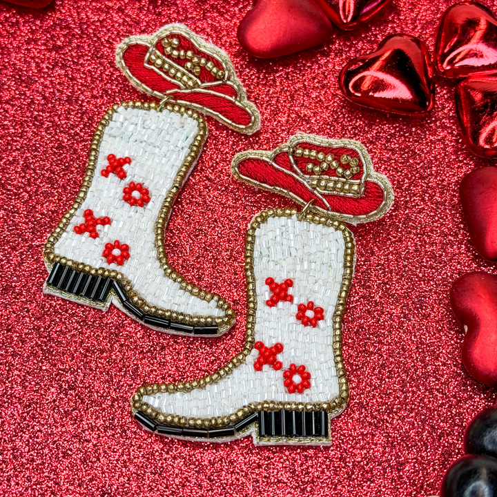 valentine's day beaded earrings with red and gold cowboy hat and white and black cowboy boots underneath hat, cowboy boots have xo xo on them in red 