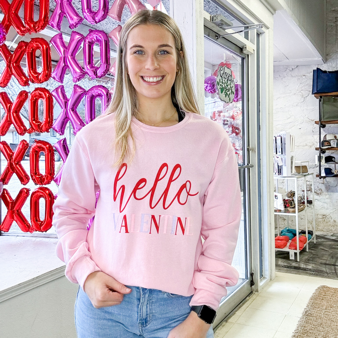 "hello valentine" valentine's day sweatshirt with hello in red script and valentine written in light purple, light pink and red block lettering 