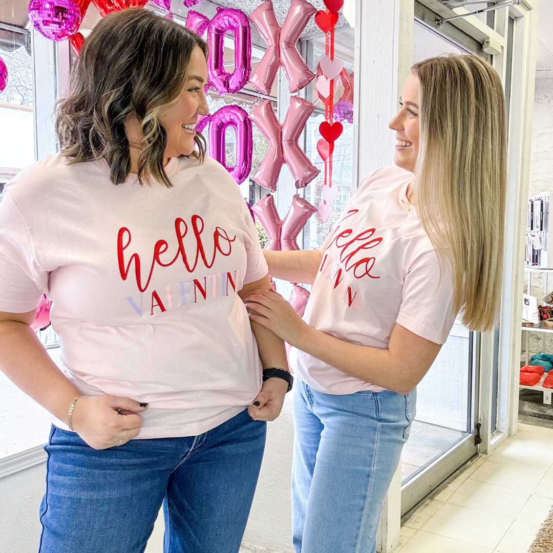 "hello valentine" valentine's day t-shirt with hello in red script and valentine written in light purple, light pink and red block lettering