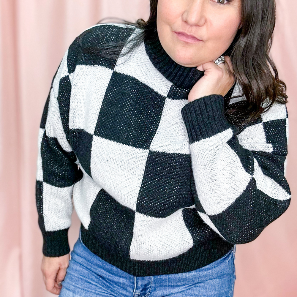Checkered Sweater, large black and white squares with a high mock neck that is ribbed sweater