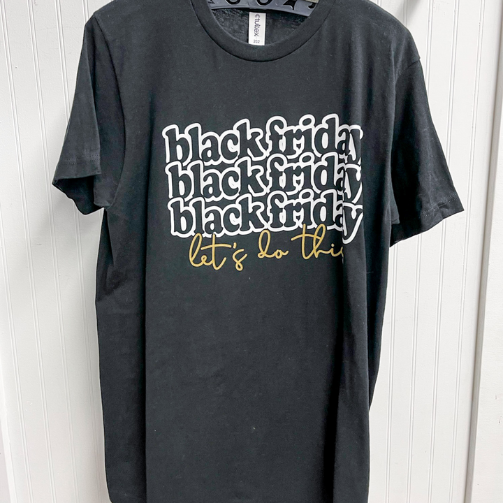 black friday let's do this graphic tee, black t shirt with black friday in bubble font in a white font, underneath it says let's do it in gold.