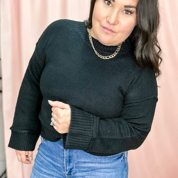 black lightweight sweater, ribbed cuffed sleeves and ribbed around the bottom of the sweater
