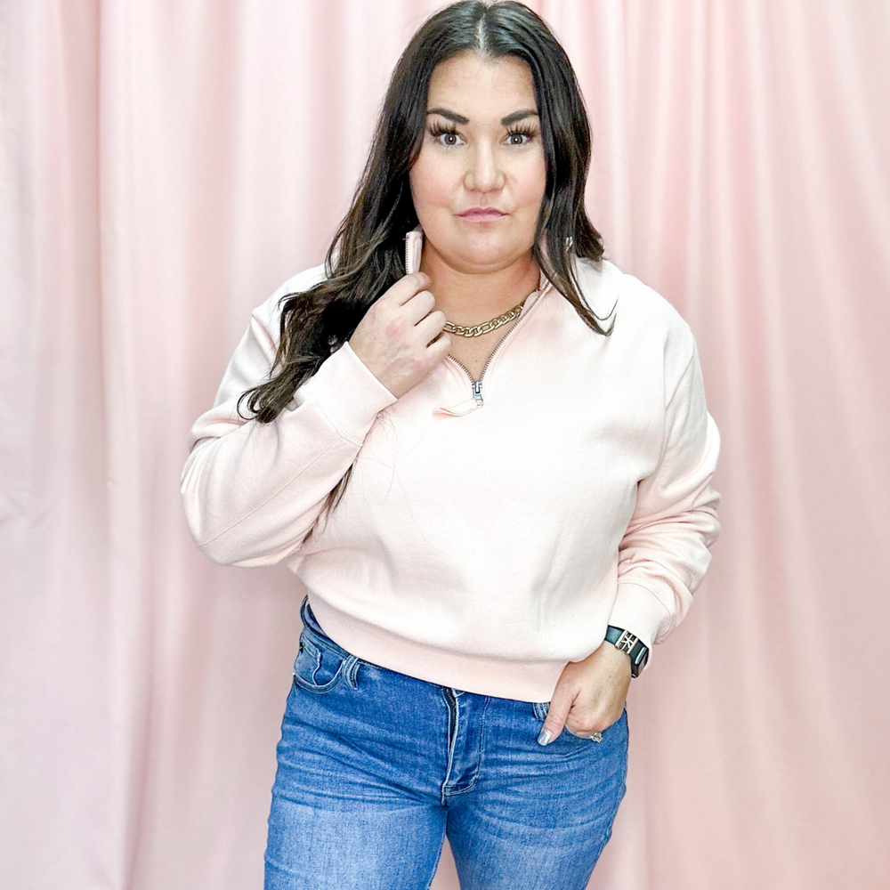 blush, light pink colored quarter zip, sweatshirt material, elastic cuffs and bottom, pairs with leggings, shorts, or jeans, can be dressed up or worn running errands