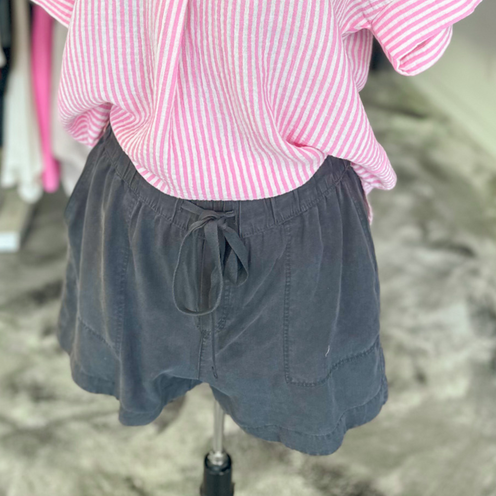 charcoal colored tilley shorts, super soft fabric, functioning pockets and jaw string, relaxed fit. pin stripe pink and white polo, v-neck top made out of gauze type fabric, cuffed sleeves and pleated front. 