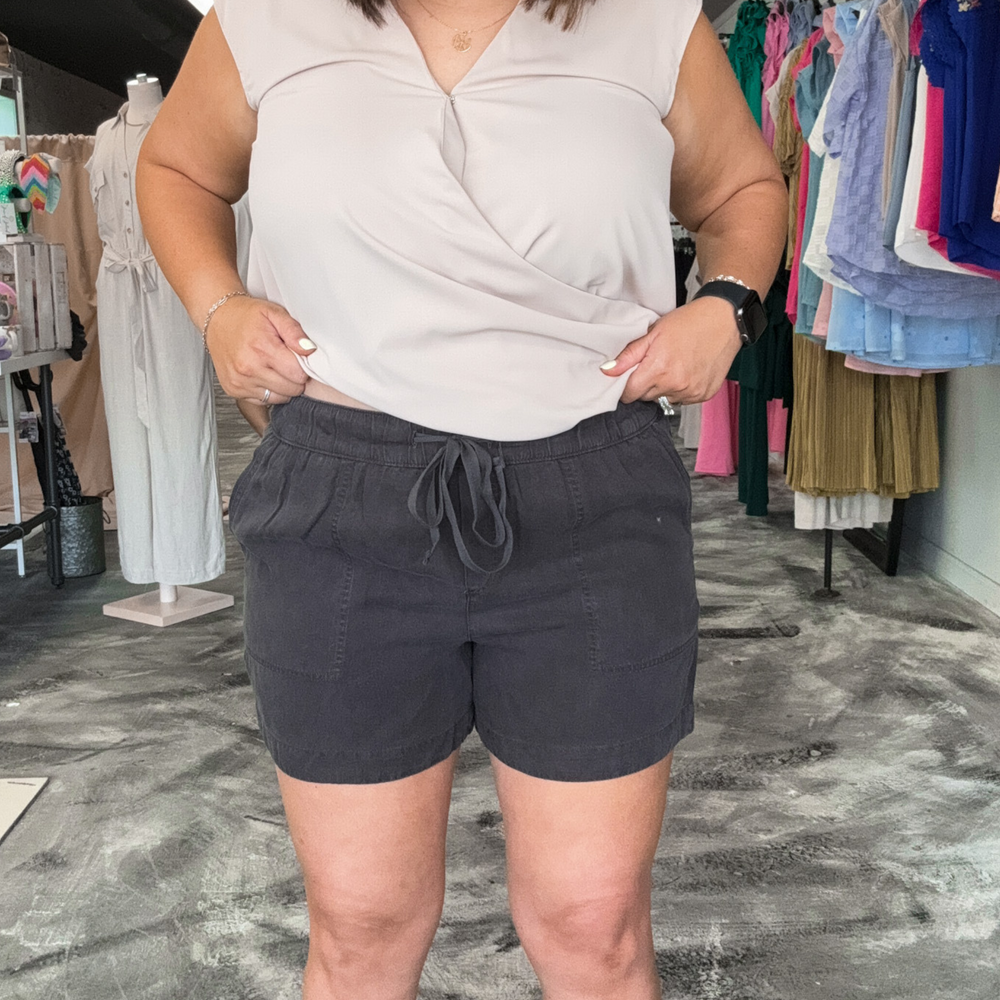 charcoal colored tilley shorts, super soft fabric, functioning pockets and jaw string, relaxed fit. pin stripe pink and white polo, v-neck top made out of gauze type fabric, cuffed sleeves and pleated front.