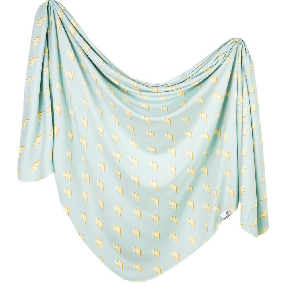 copper pearl bolt knit swaddle blanket. yellow lightening bolts on a light blue blanket.