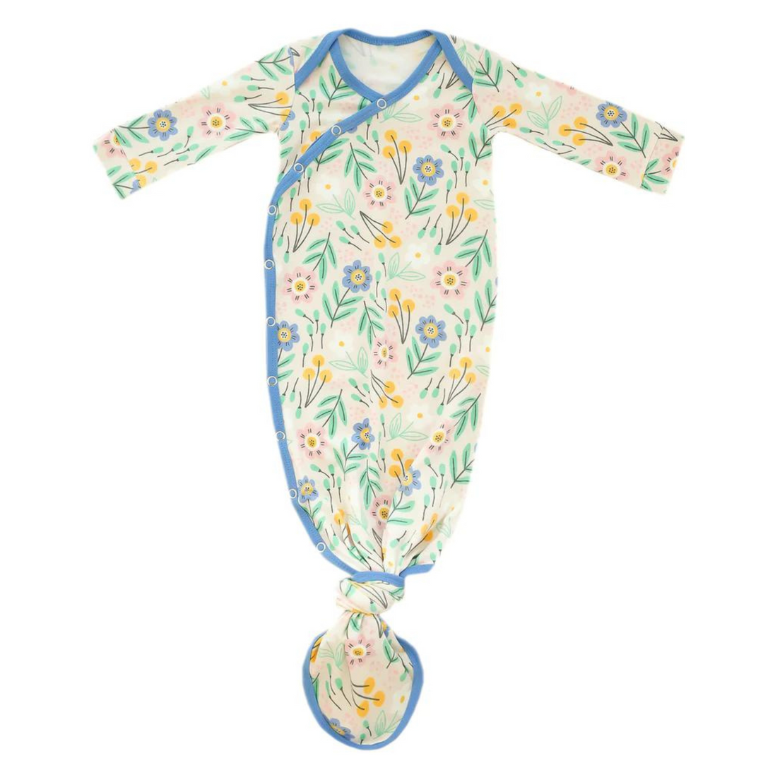 copper pearl knotted baby gown, clara print, cream background with different types of flowers in blues, greens, yellows and pinks, blue trim, snap button, knotted at the bottom so it can grow with baby. 