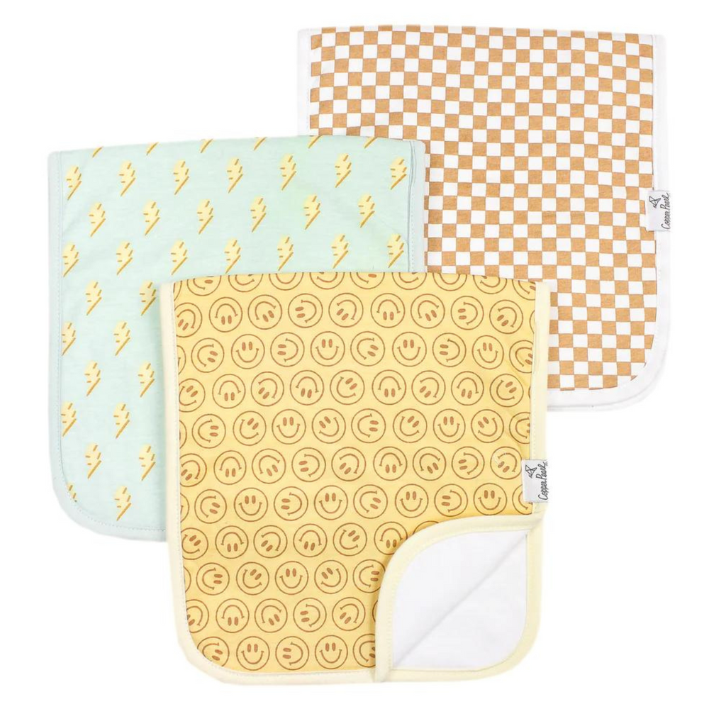 copper pearl vance 3 pack burp cloths. one yellow with brown smiley face. one light blue with yellow lightening bolts. one white and brown square pattern. 