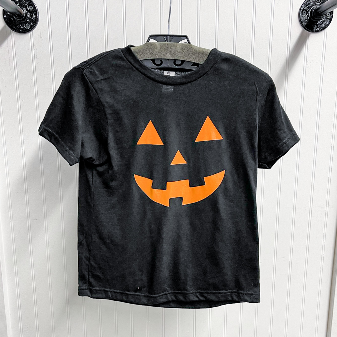 black kids tee shirt with orange jack-o'-lantern face cut out. 