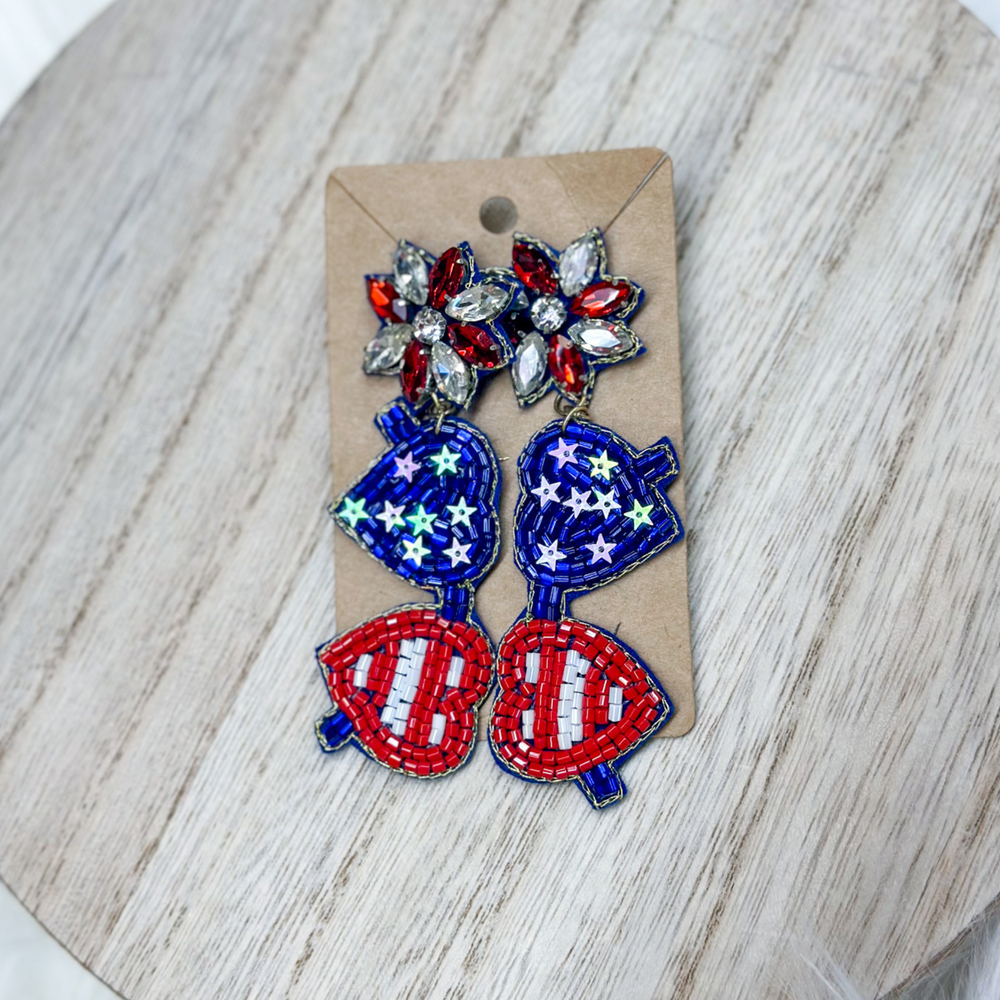 patriotic heart aviator beaded earrings, the lenses are in the shape of hearts, one heart is red and white stripes, one heart is blue with white stars, post is red and white gems.