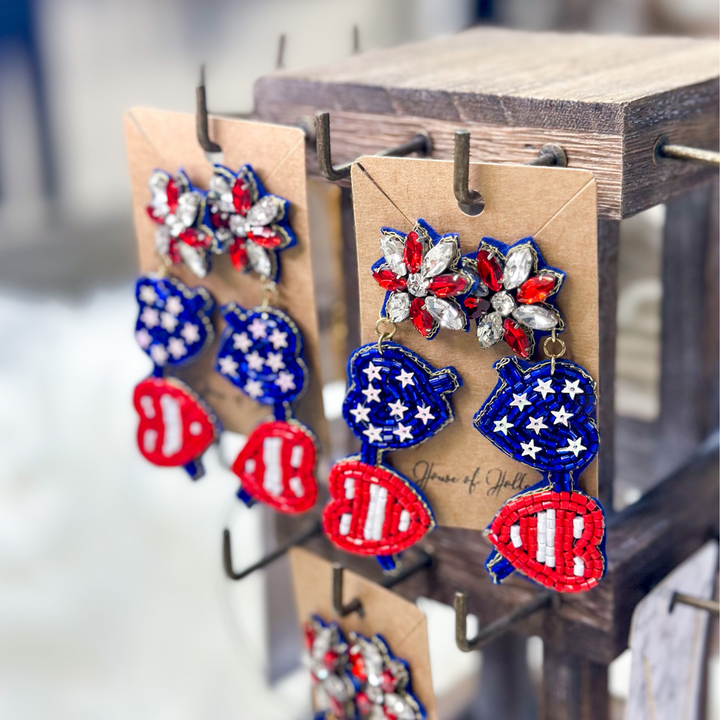 patriotic heart aviator beaded earrings, the lenses are in the shape of hearts, one heart is red and white stripes, one heart is blue with white stars, post is red and white gems.