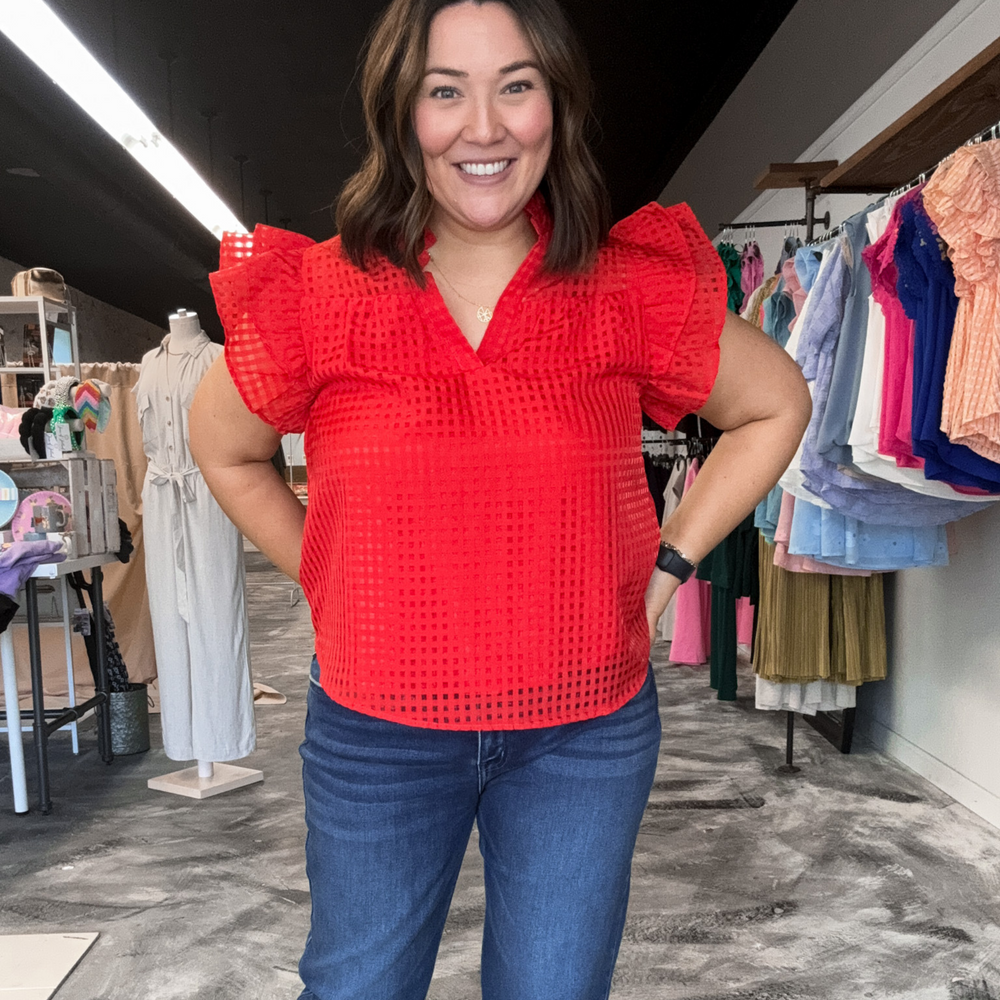 Red checkered short sleeve top with ruffle sleeves and a v-neckline.