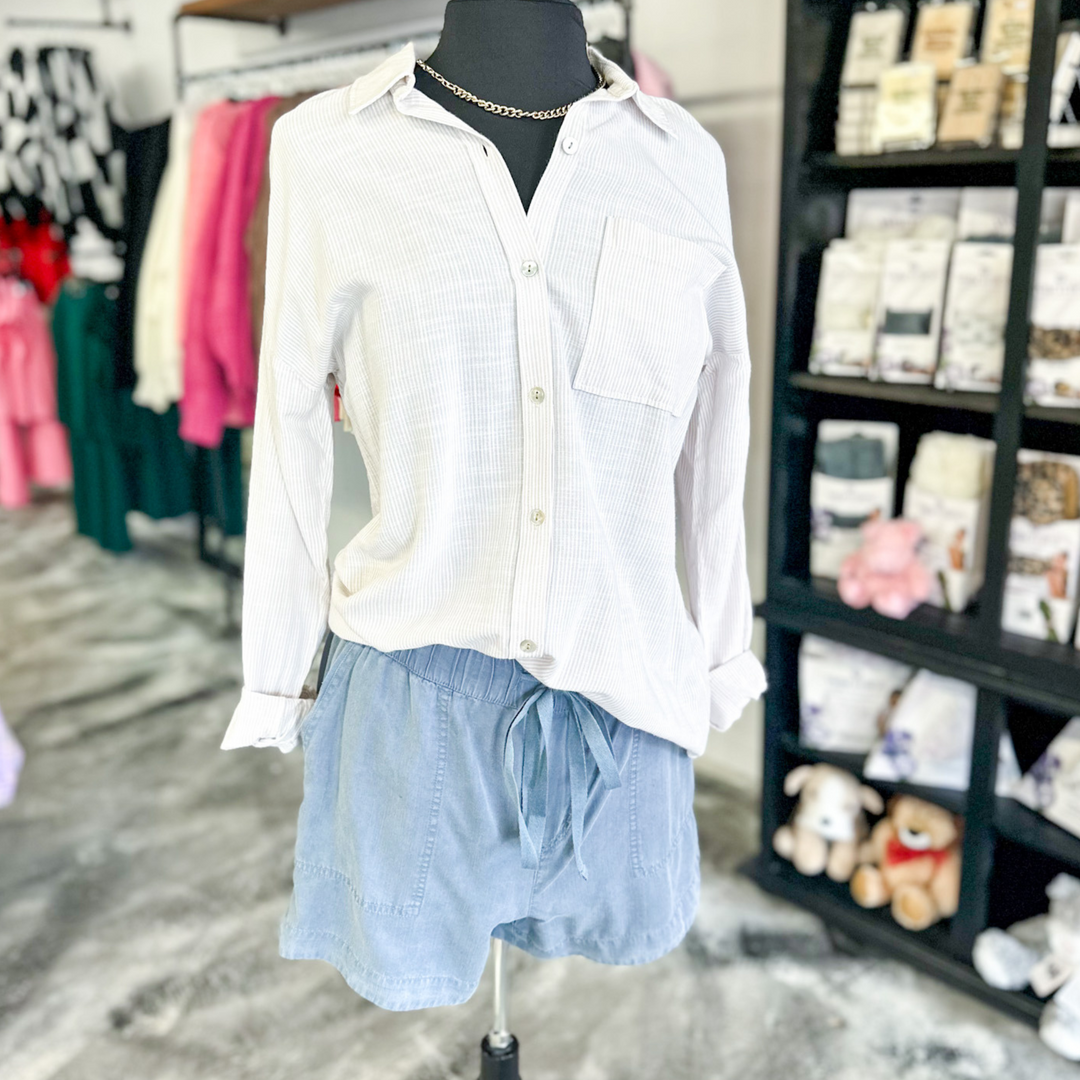 slate blue colored tilley shorts, super soft fabric, functioning pockets and jaw string, relaxed fit. very thin pin striped button up shirt in an oatmeal and cream color. 