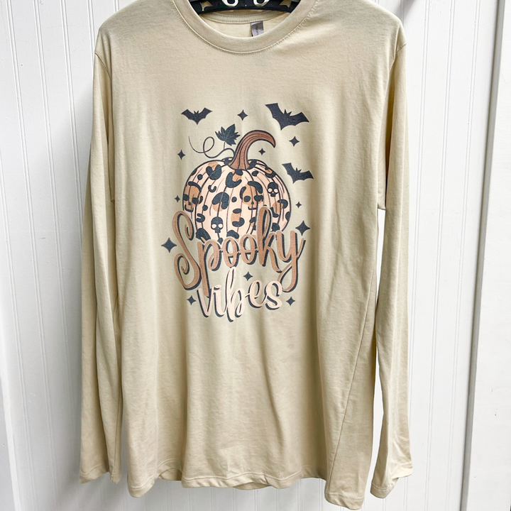 spooky vibes long sleeve tee shirt, tan long sleeve shirt with a leopard pumpkin, bats around the top, spooky vibes graphics under the pumpkin in a script font in two different colors. 
