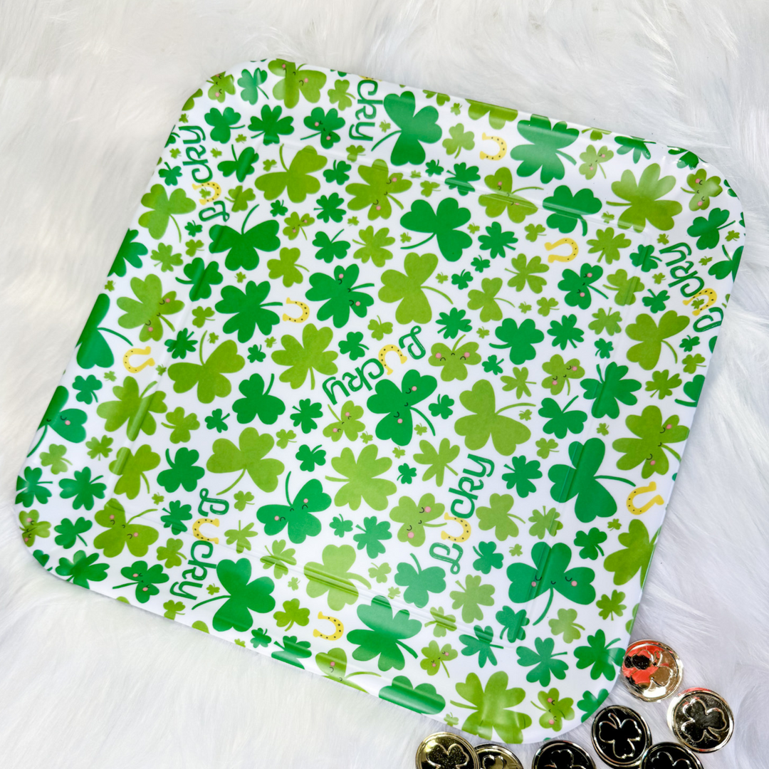 St. Patrick's Day melamine platter, 4 leaf clovers in different shades of green on a white background, gold horseshoes, the word lucky in green cursive with the "u" as a gold horseshoe. 