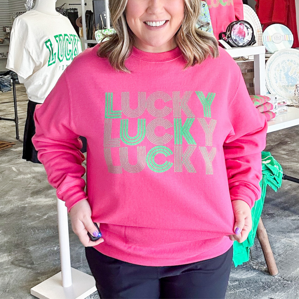 St. Patrick's day sweatshirt, raspberry pink with the word lucky screen printed in green with a line type font. 
