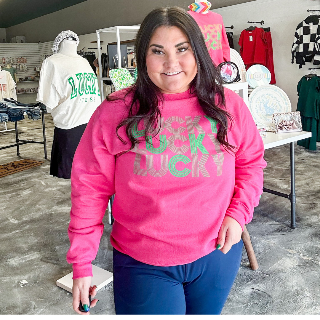 St. Patrick's day sweatshirt, raspberry pink with the word lucky screen printed in green with a line type font. 