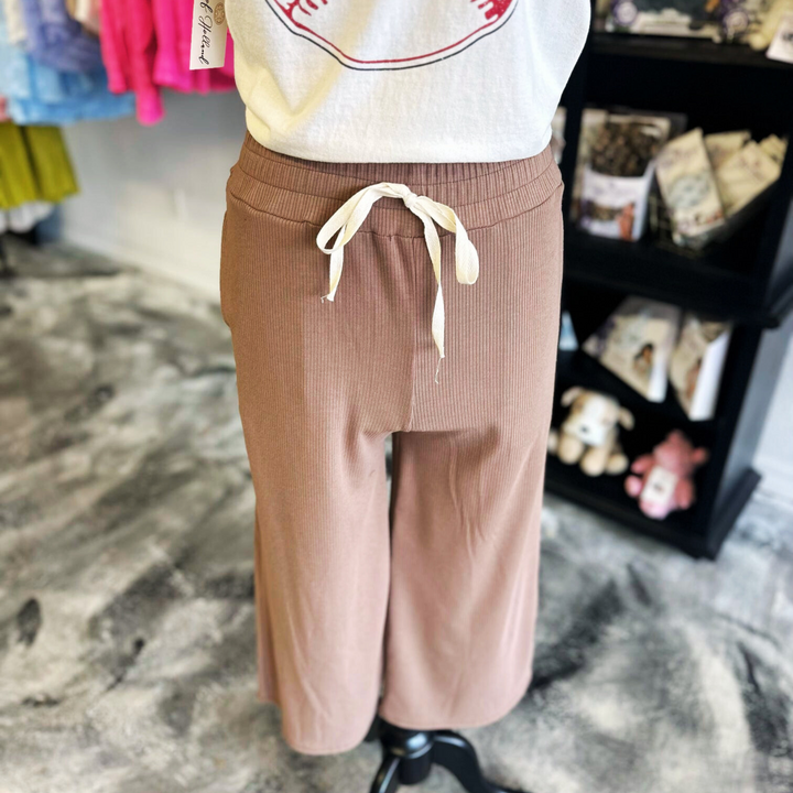 brown capri sweatpant with white tie in front.