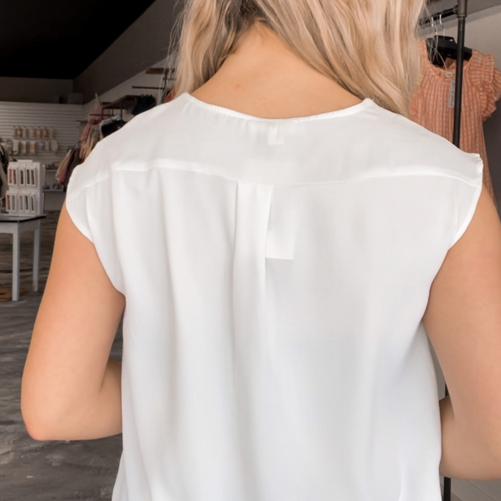 V-neck blouse with a wrap front detail, offered in khaki, light blue, and white.
