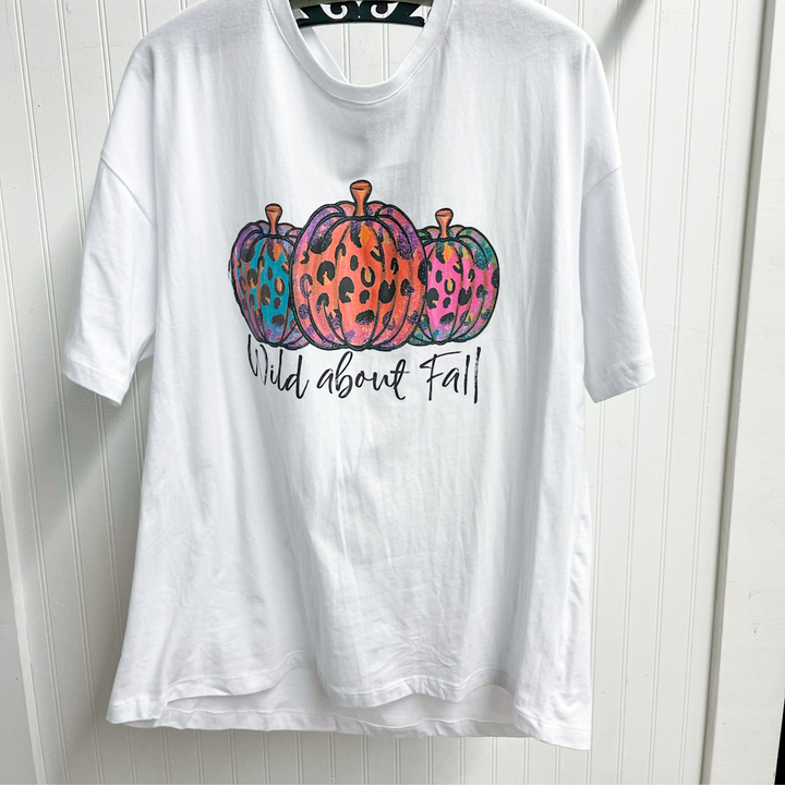 wild about fall fall graphic tee, white round neck tee shirt with 3 pumpkins with multi color leopard on them, under the pumpkins in a black script font it says wild about fall. 