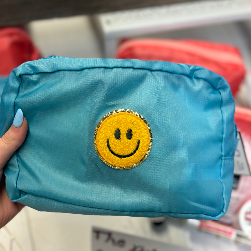 yellow smiley patch aqua makeup bag with dark teal zipper.